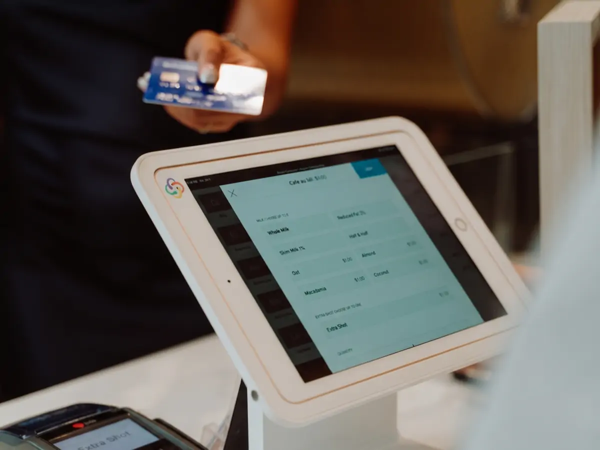 A customer paying by card at a tablet POS terminal in a store - the kind of checkout our retail POS software runs