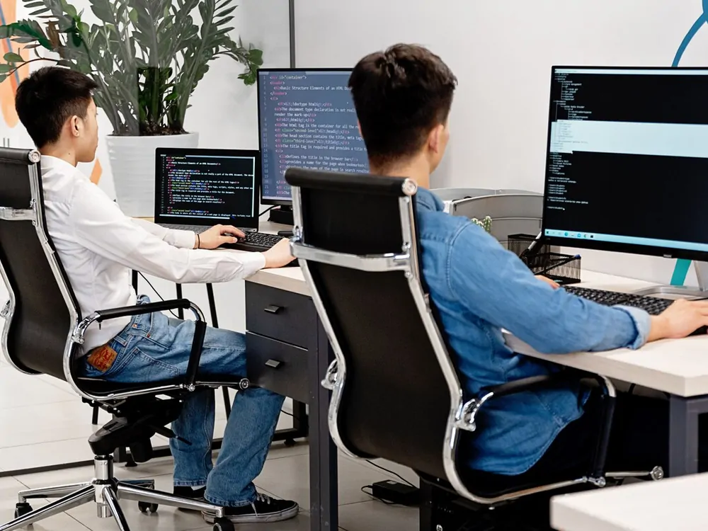 Two Silex engineers writing code at their desks